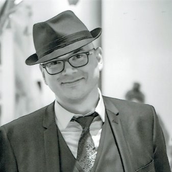 Portrait en noir et blanc de Vincent Kopa portant un chapeau et des lunettes